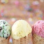 A close-up of three ice cream cones, mine chocolate chip on the left, vanilla in the middle, and strawberry on the right.