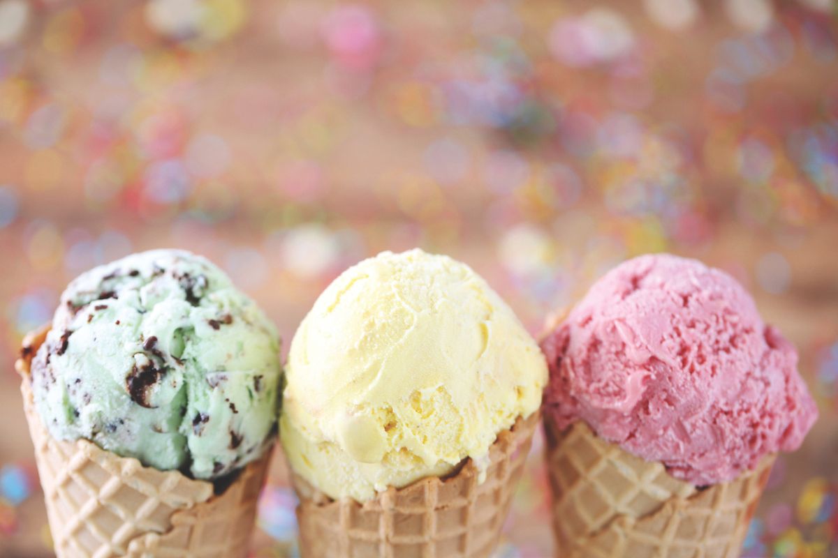 A close-up of three ice cream cones, mine chocolate chip on the left, vanilla in the middle, and strawberry on the right.