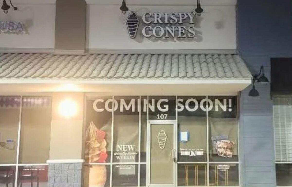 A dark storefront with a large sign reading, "Crispy Cones."