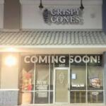 A dark storefront with a large sign reading, "Crispy Cones."