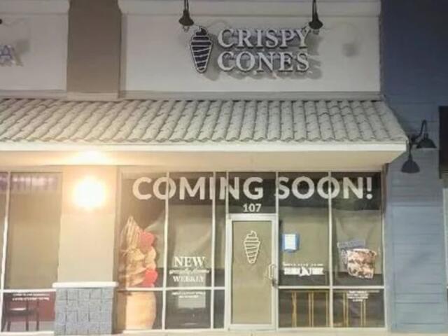 A dark storefront with a large sign reading, "Crispy Cones."