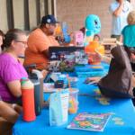 A table on an open store strip with Legos and customers.