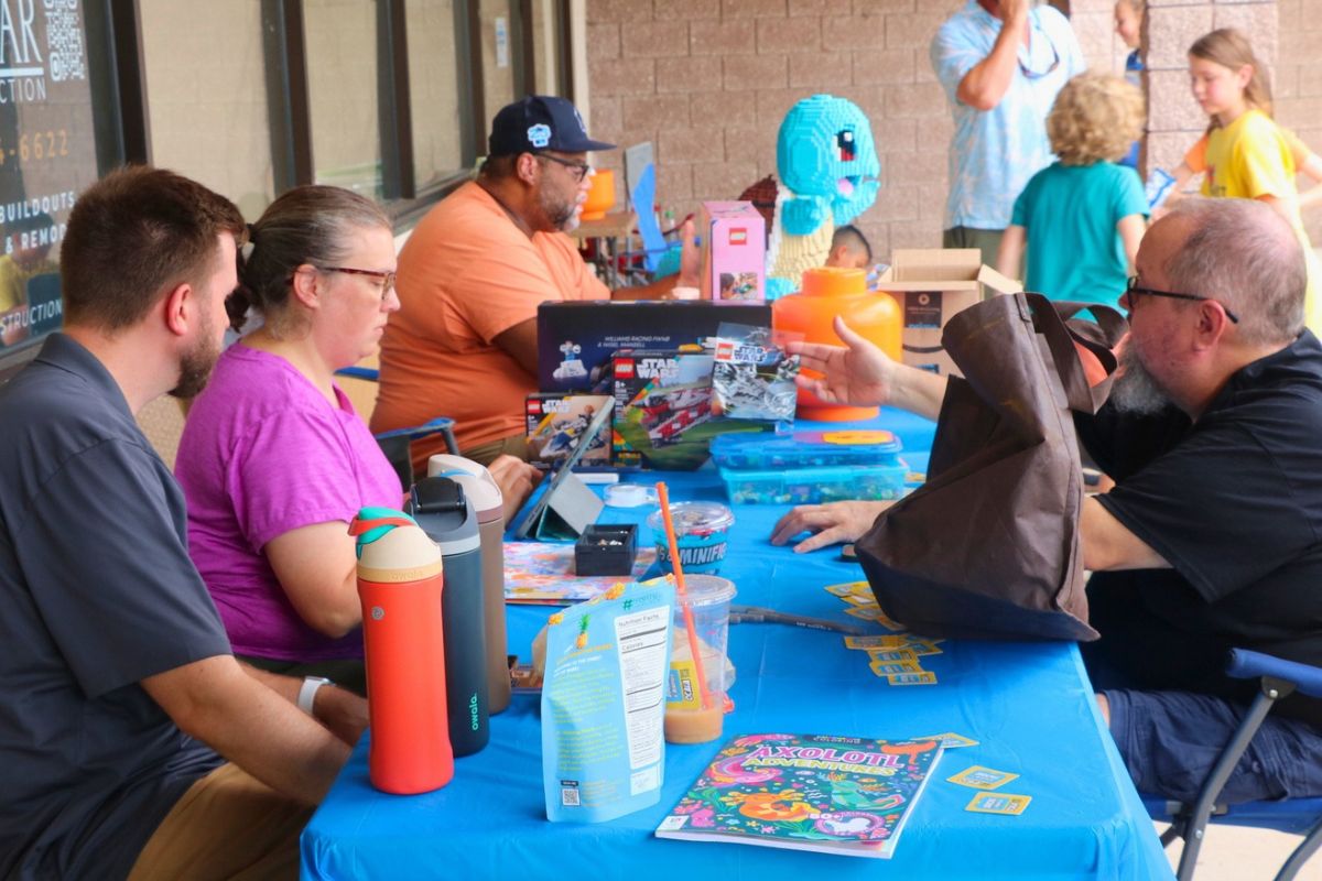 A table on an open store strip with Legos and customers.