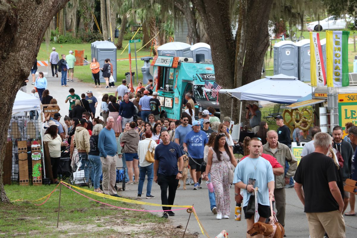 Crowd walks through town festival.