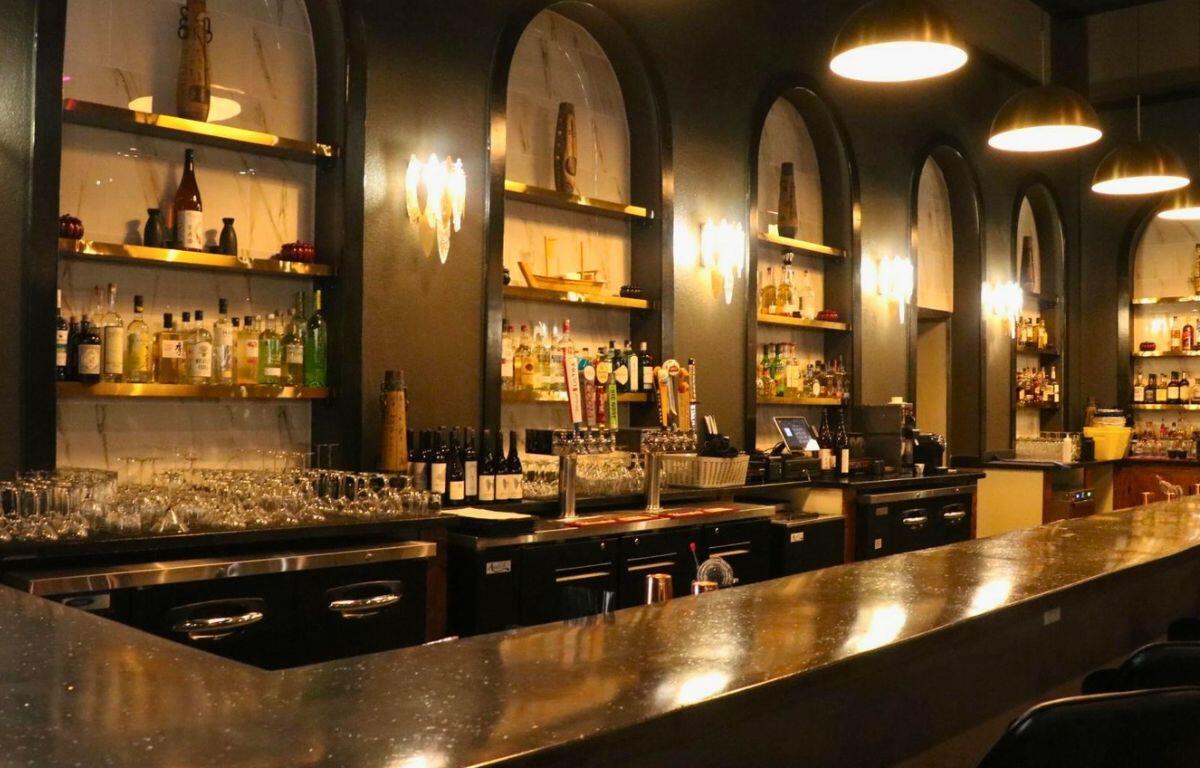 A dimly lit bar in the corner of a restaurant.