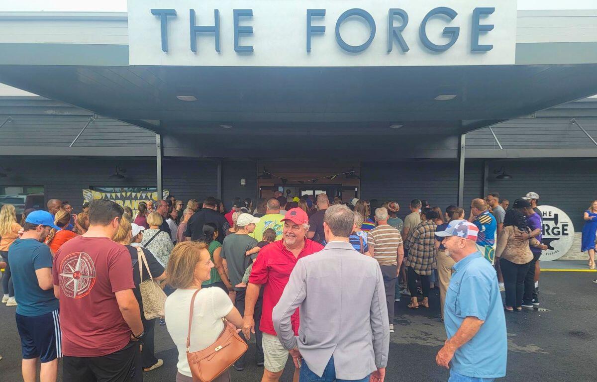 Crowd of people enter building with a sign reading, "The Forge."